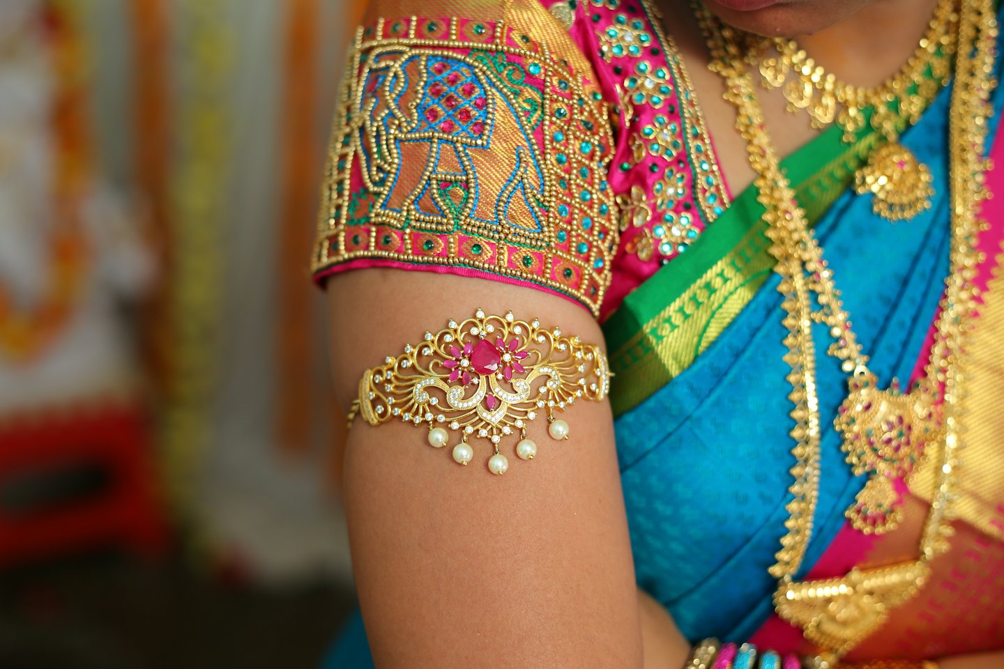 Woman wearing a traditional silk saree and ornate gold jewelry.